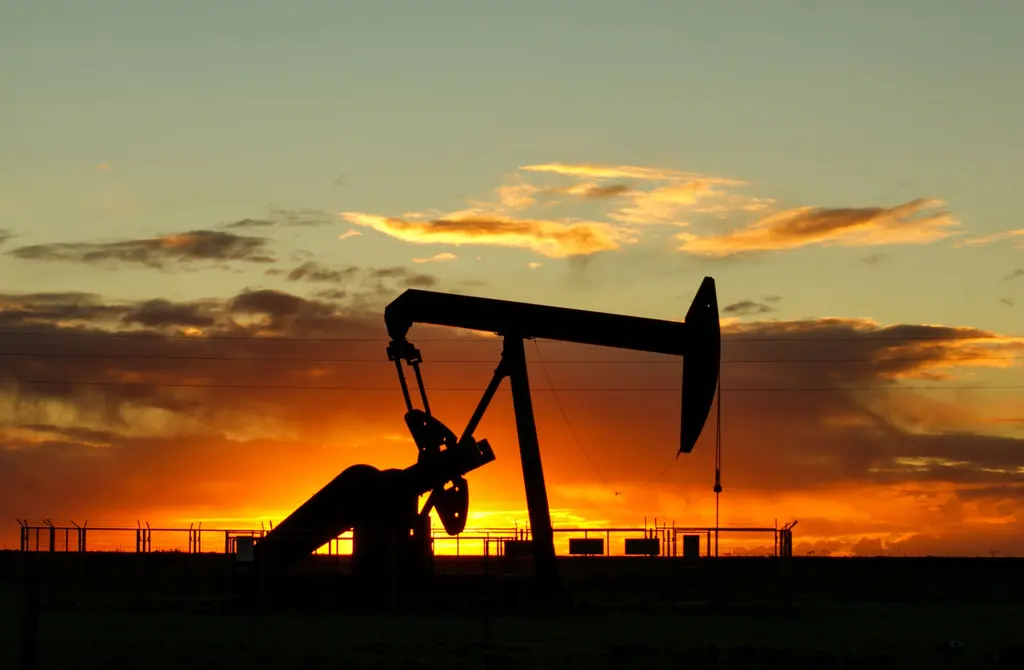 Oil pump jack silhouetted against a sunset sky