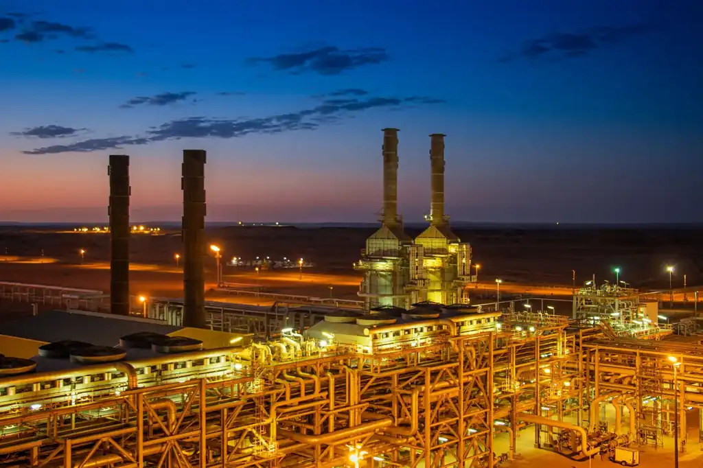Industrial plant with chimneys lit at sunset, seen from above